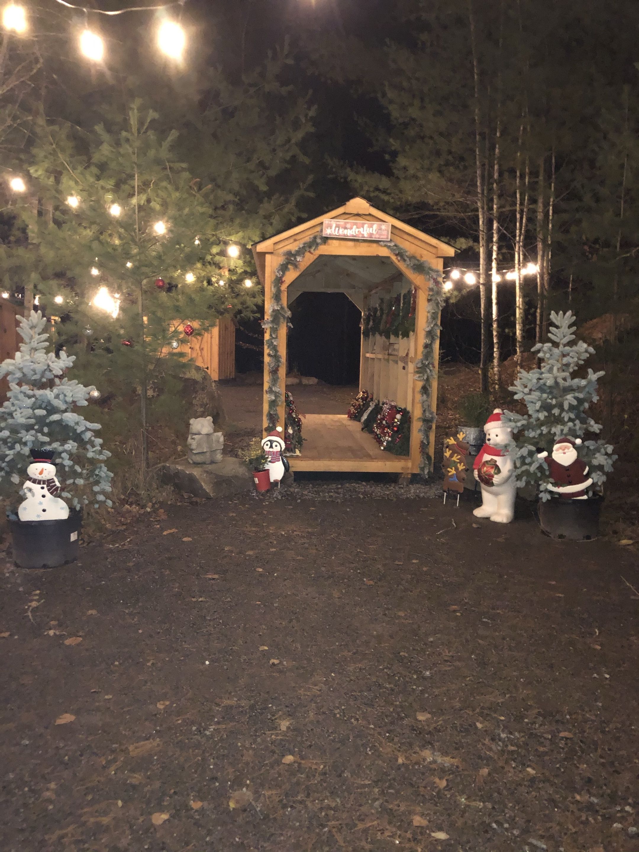 Holiday Market entrance with string lights and snowmen at night